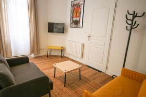 una sala de estar con un sofá y una mesa en Le Pop Art - Parking Privé, en Angulema