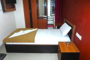 a small bedroom with a bed and a table at King Residency in Bangalore