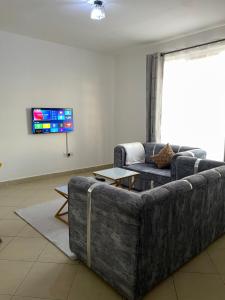 a living room with a couch and a tv at Snowhaven One bedroom accomodation Kitengela in Kitengela 