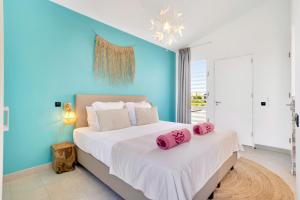a bedroom with a bed with pink pillows on it at Delfins Residences in Kralendijk +36 photos