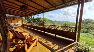 a porch with chairs and a view of the forest at Casa Cabuya - Retro Style with Gulf View in Monteverde in Monteverde Costa Rica