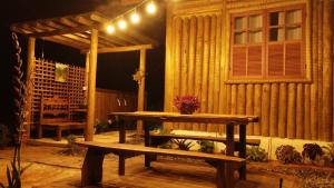 a wooden table and a bench in front of a building at Chalés do Caminho - Aconchego in Santa Rita do Rio Abaixo +11 photos