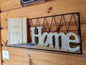 a sign that says home hanging on a wall at Le Ptit Beccon in Cruseilles