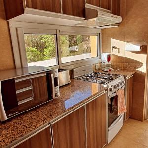 a kitchen with a stove top oven next to a window at Apart Santa Marta in Salta