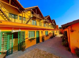 a row of buildings with yellow and orange at Pousada Villa Três in Serra Negra