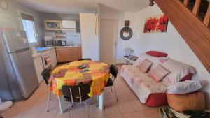 a kitchen with a table and a bed in a room at Maisonnette familiale climatisée dans résidence avec piscine in Vic-la-Gardiole