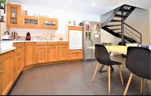 a kitchen with wooden cabinets and a table with chairs at Maison de Village 4 chambres in Sabran +6 photos