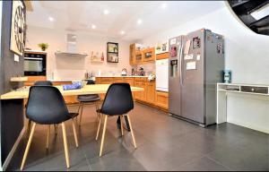 a kitchen with a table and chairs and a refrigerator at Maison de Village 4 chambres in Sabran