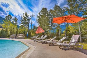 a group of chairs and an umbrella next to a pool at Riverbend Townhomes by StayIn in Panorama