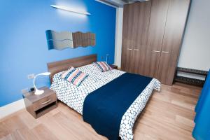 una camera blu con un letto e un comodino di Be Happy a Ferrara
