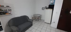 a living room with a chair and a couch at Flat no centro de pindamonhangaba in Pindamonhangaba