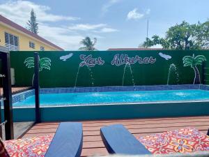 a swimming pool with two blue chairs next to a fence at Las Alturas Loft 301 in Aguadilla