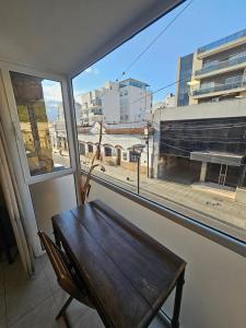a table and a chair in a room with a window at Apart Santa Marta in Salta