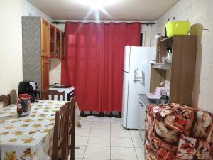 a kitchen with a table and a red curtain at Apto 20 QUADRA PRAIA CISSA in Itapoa