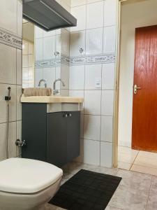 a bathroom with a sink and a toilet at Suite Delfinopolis in Delfinópolis