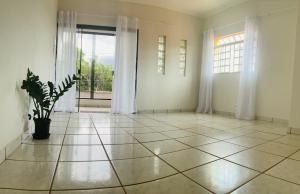 an empty room with a potted plant and a window at Suite Delfinopolis in Delfinópolis +1 photo
