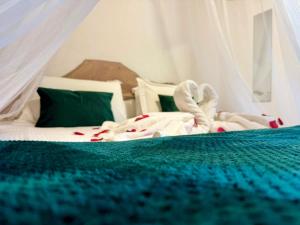 a bedroom with a bed with a green comforter at Casas da Quinta in Santa Cruz das Flores