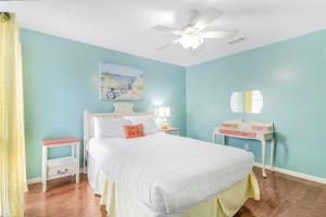 a bedroom with a white bed and blue walls at Fun In The Sun by Vacation Homes Collection in Orange Beach +100 photos