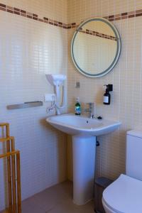 Un baño con lavabo, espejo e inodoro. en Balcon mirador de las Salinas, en Sanlúcar de Barrameda 22 fotos más