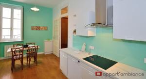 a kitchen with blue walls and a table and chairs at Appart' Odeon in Lyon