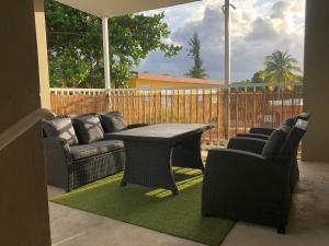a patio with couches and a table and chairs at Las Alturas Loft 304 in Aguadilla