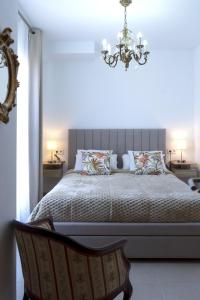 Un dormitorio con una cama grande y una lámpara de araña. en Balcon mirador de las Salinas, en Sanlúcar de Barrameda