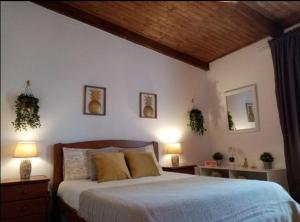 a bedroom with a bed with two lamps and two mirrors at Casa Rustica - Courtyard House in Olhão