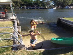 two children playing in the water at a park at Mandurah Riverfront Holiday Rental in North Yunderup