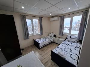 a bedroom with two beds and two windows at Bubolina House in Sapareva Banya