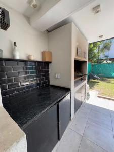 una cucina con piano di lavoro nero in una camera di Casa ALI, cuenta con 4 camas individuales y una cama matrimonial, capacidad máxima 6 personas a Yerba Buena 1 altra foto