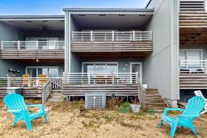 two blue chairs sitting in front of a house at Tar Landing Villas 306 in Atlantic Beach