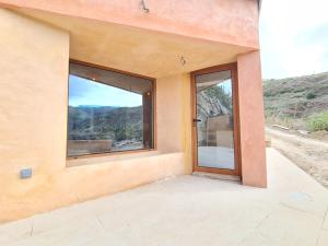 a house with large windows in the side of it at Los Andenes Nest in San José de Caideros
