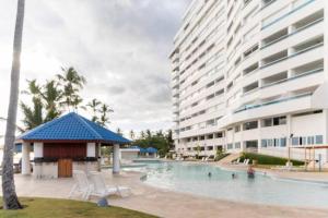 a swimming pool in front of a large building at Luxury Beachfront 2BR at Las Olas, Juan Dolio in La Puntica de Juan Dolio