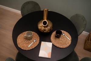 a black table with two cups and a vase on it at Green Luxury Zamenhof in Valencia +27 photos