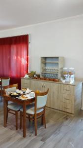 - une cuisine avec une table et des chaises en bois ainsi qu'un comptoir dans l'établissement Hotel Majestic, à Villa Giardino