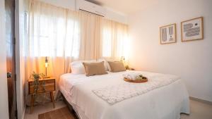 a bedroom with a white bed with a table on it at Ketsys Home Near Santo Cerro in Concepción de La Vega
