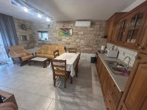 a kitchen and living room with a table and a couch at APP GAŠI in Buje