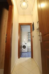 a hallway with a washer and dryer in a room at City center apartment in Nafpaktos
