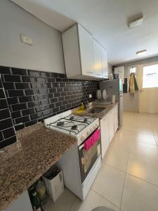 una cucina con fornelli e piano di lavoro di Casa ALI, cuenta con 4 camas individuales y una cama matrimonial, capacidad máxima 6 personas a Yerba Buena