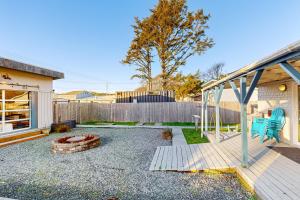 a backyard with a wooden deck and a fire pit at Rockaway Beach Villa in Rockaway Beach