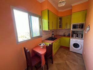 a kitchen with green cabinets and a table and a window at Casa Rural Los Tilos Betancor in Moya