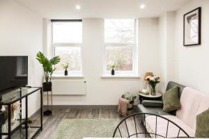 プレストンにあるComfortable Apartment in desirable area of Prestonのソファと2つの窓があるリビングルーム