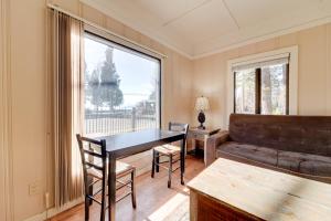 a living room with a table and a large window at Spa and Beach Access Resort Condo in Tahoe Vista! in Tahoe Vista