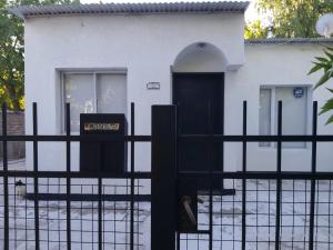 a white house with a black door and a fence at Casablanca in La Adela