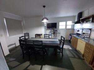 Una habitación con una mesa y sillas en una cocina. en Casablanca, en La Adela
