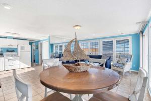a kitchen and dining room with a wooden table and chairs at Ocean front Rental 101-3 in Tybee Island