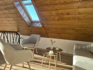 a room with wooden ceilings and chairs and a table at Domek Przekop in Sromowce Wyżne +9 photos