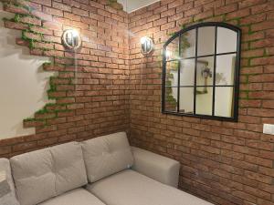 a brick wall with a couch in front of a mirror at Domek Przekop in Sromowce Wyżne