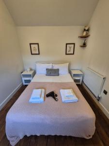 une chambre avec un lit avec deux serviettes dessus dans l'établissement The Nook, 1 Bedroom Cottage with Indoor Fireplace, à Poundon