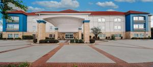 a large brick building with an arch in front of it at Sonesta Essential Houston Westchase in Houston